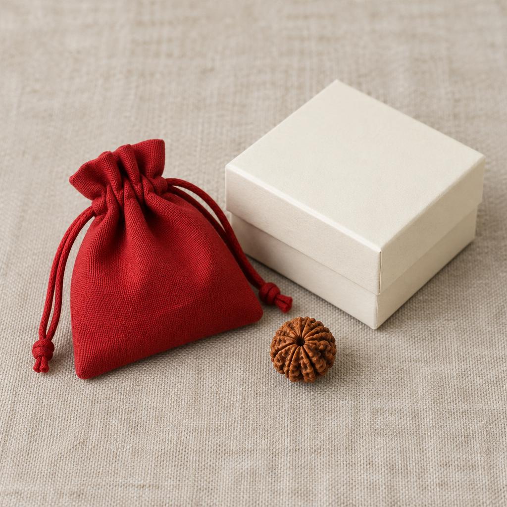 Red cloth pouch and ivory box beside a Rudraksha bead (illustrative packaging)